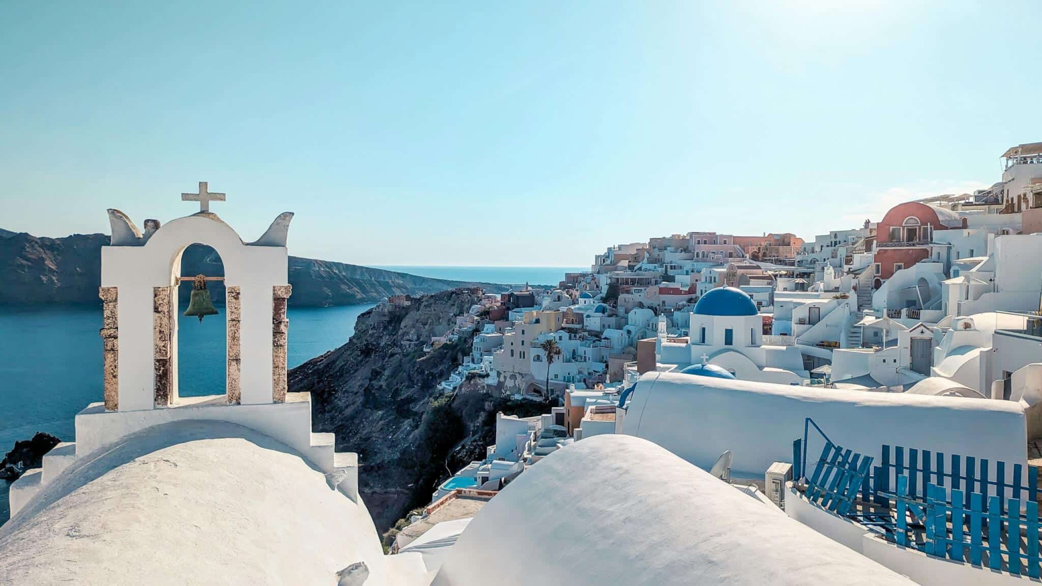 Luxury Santorini view with white buildings, blue domes and bell tower